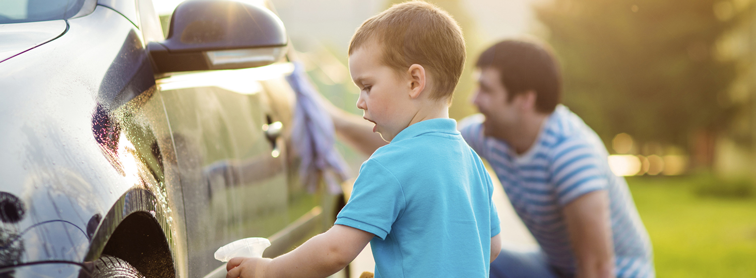 Father and son cleaning a car